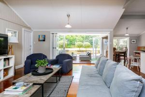 een woonkamer met een bank en een tafel bij Garden Cottage 1Brm Private & Spacious in Brisbane