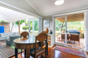 a dining room with a table and chairs in a living room at Garden Cottage 1Brm Private & Spacious in Brisbane