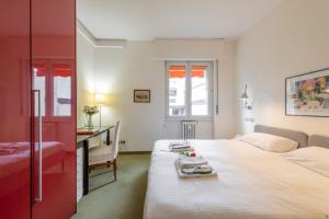 een slaapkamer met een bed en een bureau en een bed bij BnButler - Cesare Brivio, 21 - Ampio e Luminoso in Milaan