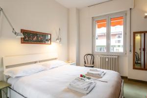 een slaapkamer met een wit bed en een raam bij BnButler - Cesare Brivio, 21 - Ampio e Luminoso in Milaan