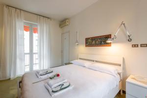 een slaapkamer met een wit bed met handdoeken erop bij BnButler - Cesare Brivio, 21 - Ampio e Luminoso in Milaan +15 foto's