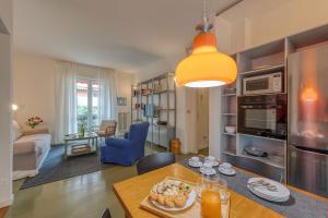 een keuken en een woonkamer met een tafel met eten erop bij BnButler - Cesare Brivio, 21 - Ampio e Luminoso in Milaan