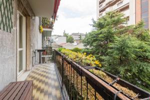 een balkon met een bank en bloemen op een gebouw bij BnButler - Cesare Brivio, 21 - Ampio e Luminoso in Milaan