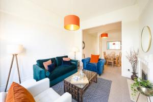 a living room with two blue couches and a table at Spacious and quiet ground floor flat in Bristol