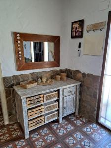 y baño con tocador de madera y espejo. en Hacienda Tresoles en Ubrique