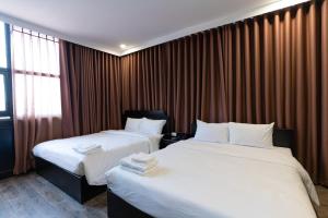 a hotel room with two beds and a window at Queen Central Hotel - Ben Thanh Market in Ho Chi Minh City