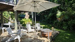 a patio with a table and chairs and an umbrella at Magnetic Mango Escape in Horseshoe Bay