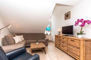 Una sala de estar con un sofá y un televisor. en Haus am Teich Wohnung 21, en Boltenhagen 7 fotos más