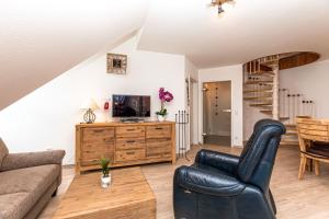 una sala de estar con un sofá y una silla en Haus am Teich Wohnung 21, en Boltenhagen