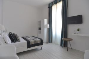 biała sypialnia z łóżkiem i stołkiem w obiekcie Lata Luxury Rooms w Rzymie