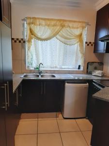 a kitchen with a sink and a window at Lihle's Paradise in Margate