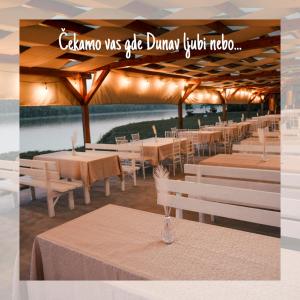 un restaurant avec des tables et des chaises et un panneau indiquant que calzone était capable de dîner dans l'établissement Florida Resort, à Bačka Palanka
