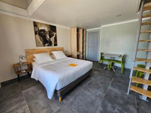 1 dormitorio con cama, mesa y escalera en La Casa del Arti - Chambres d'hôtes en Sigean
