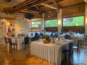 un comedor con mesas y sillas con mantel blanco en Hotel Ristorante La Casona, en Feltre