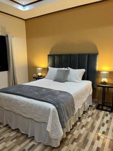 a bedroom with a large bed and two night stands at Casa Hacienda Real in Siguatepeque