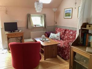 a living room with a red couch and a table at Ferienhof Spiegelhaus in Krummhörn