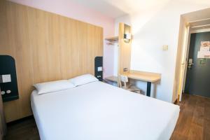 - une chambre avec un lit blanc et un bureau dans l'établissement B&B HOTEL Bordeaux Mérignac Aéroport, à Mérignac