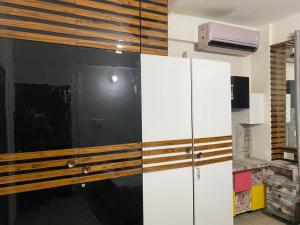 a room with a large white cabinet with wood accents at Fancy and Modern Apartment in Patna