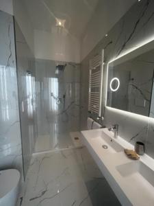 a white bathroom with a sink and a shower at Hotel Gabriella in Rome