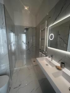 a white bathroom with a sink and a shower at Hotel Gabriella in Rome