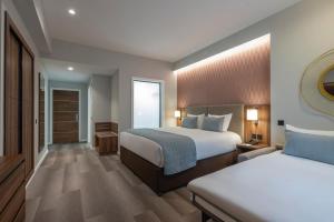 a hotel room with two beds and a window at Riu Plaza The Gresham Dublin in Dublin