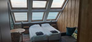 a room with a bed and a chair and windows at Happy beach in Varna City