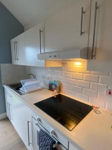 a kitchen with white cabinets and a black counter top at The Boathouse in Donaghadee