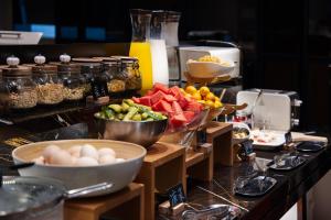 Spey Hotel في قوانغتشو: طاولة مطبخ مع صحون من الفواكه وغيرها من الأطعمة