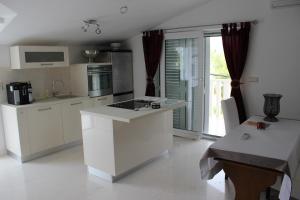 a kitchen with white cabinets and a table with a table sidx sidx sidx at Vila Vito in Trogir