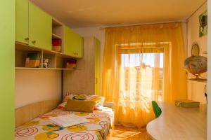 um pequeno quarto com uma cama e uma janela em Apartment Many em Pula