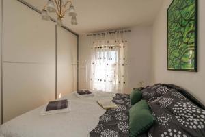 um quarto com uma cama com almofadas verdes e pretas em Apartment Many em Pula