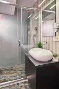uma casa de banho com um lavatório e uma cabina de duche em vidro. em ACTUEL LİFE HOTEL em Istambul