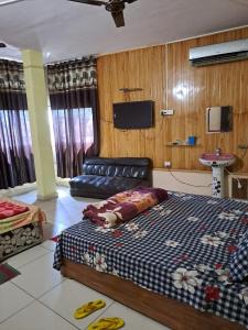 a bedroom with a bed and a couch and a tv at Stacy Guest House in Jīnd