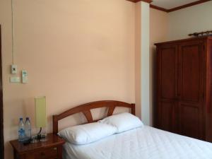 a bedroom with a white bed and a wooden cabinet at Hom Baan Chiang Mai in Chiang Mai +49 photos