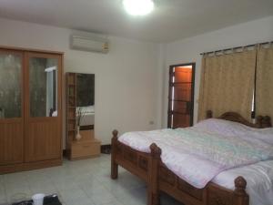 a bedroom with a bed and a dresser in it at Hom Baan Chiang Mai in Chiang Mai