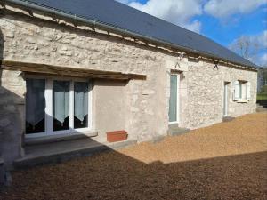 una casa de piedra con una ventana en el lateral. en Maison dans hameaux au calme, en Parçay-les-Pins