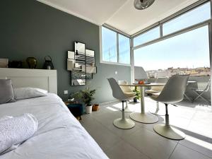 um quarto com uma cama, uma mesa e cadeiras em Cosy Penthouse in Hamrun - Walking distance to Valletta em Hamrun