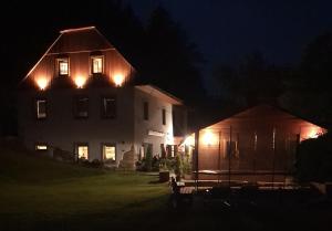 a house with lights on the side of it at night at Penzion Čtyřlístek in Teplice nad Metují