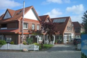 ein Haus mit Sonnenkollektoren auf dem Dach in der Unterkunft Pension Arndt UG in Wangerland