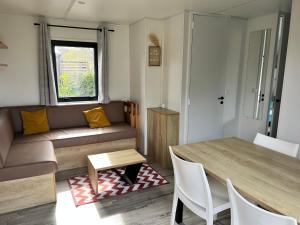 salon z kanapą i stołem w obiekcie Mobilhome Camping Biscarrosse 5 étoiles bord du lac w mieście Biscarrosse