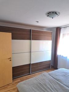 Schlafzimmer mit Holzschiebetüren und einem Bett in der Unterkunft Hof Helmenhube 2 in Gammelsbach