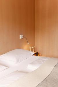 A bed or beds in a room at Hotel Post Bezau