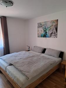 Bett in einem Schlafzimmer mit Wandgemälde in der Unterkunft Hof Helmenhube 2 in Gammelsbach