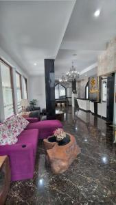 un soggiorno con divano viola e tavolo di HOTEL DHD a Banjar