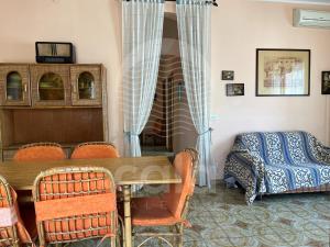 Pokój ze stołem, krzesłami i łóżkiem w obiekcie Villa Corallo By Cala Salento w mieście Torre Lapillo