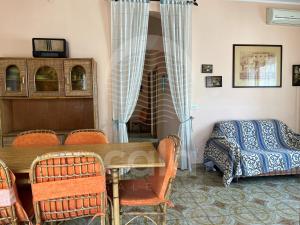 トッレ・ラピッロにあるVilla Coralloのテーブル、椅子、ベッドが備わる客室です。