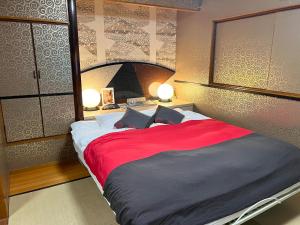 1 dormitorio con 1 cama grande con manta roja en ホテル 夢街道, 