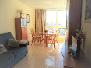 a living room with a blue couch and a table and chairs at Ola Azul Sea View Apartment in Benidorm