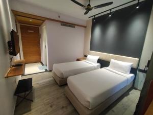 ein Hotelzimmer mit 2 Betten und einem TV in der Unterkunft TERRACE BUSINESS HOTEL KOZHIKODE in Kozhikode