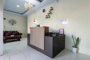 a lobby with a reception desk and a couch at RedDoorz @ Simpang Pemda Medan in Medan